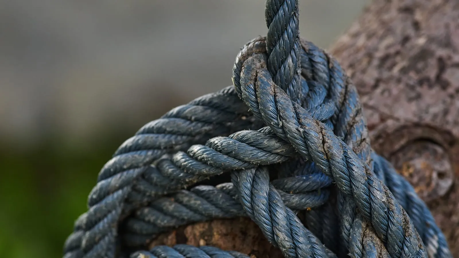 A weathered blue rope twisted into a tight knot