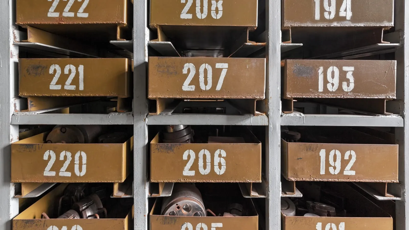 Rows of numbered storage bins full of parts in a workshop